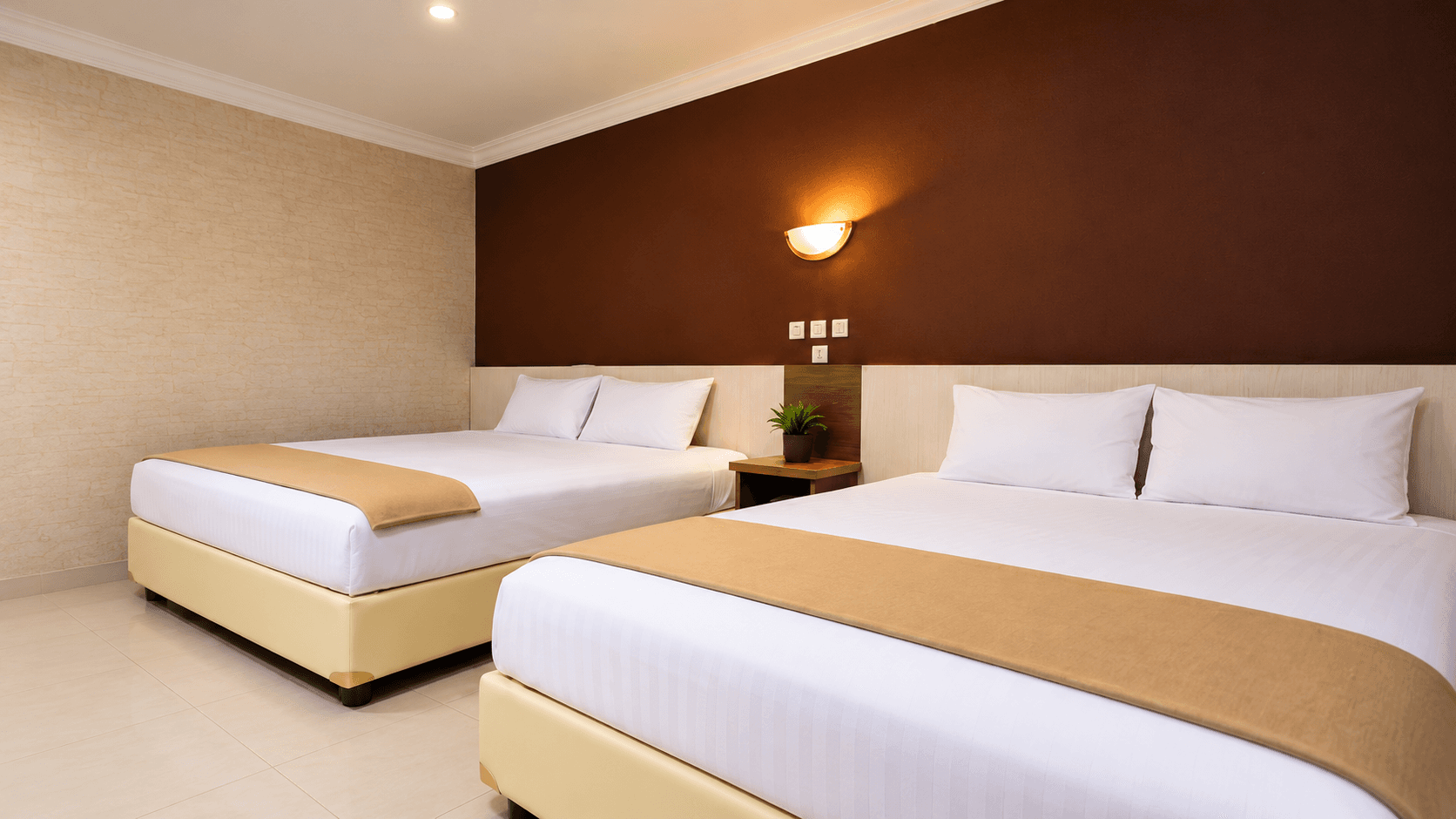 Kamar nyaman dengan dua tempat tidur besar di Safara Hotel Yogyakarta